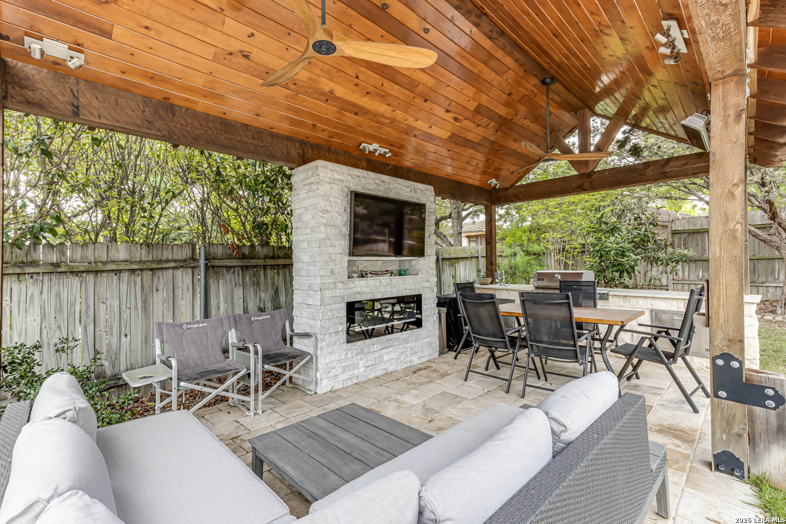 15919 Mission Ridge San Antonio, TX 78232 - Photo 40 of 43 a outdoor space with furniture a fireplace and a garden view