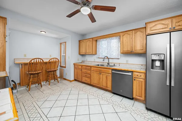 a kitchen with stainless steel appliances granite countertop a sink cabinets and a window