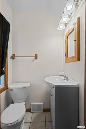 a bathroom with a toilet sink and mirror