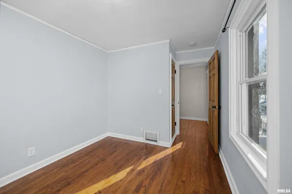 a view of a room with wooden floor and a window