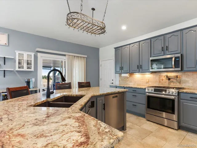 a kitchen with stainless steel appliances granite countertop a sink stove and cabinets