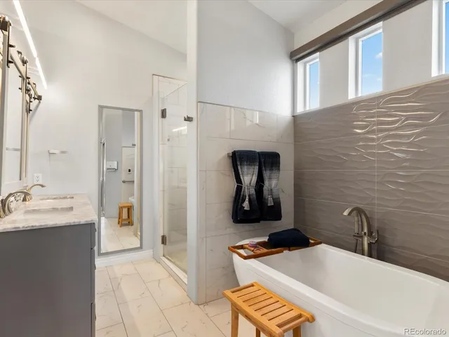 a bathroom with a tub sink and mirror