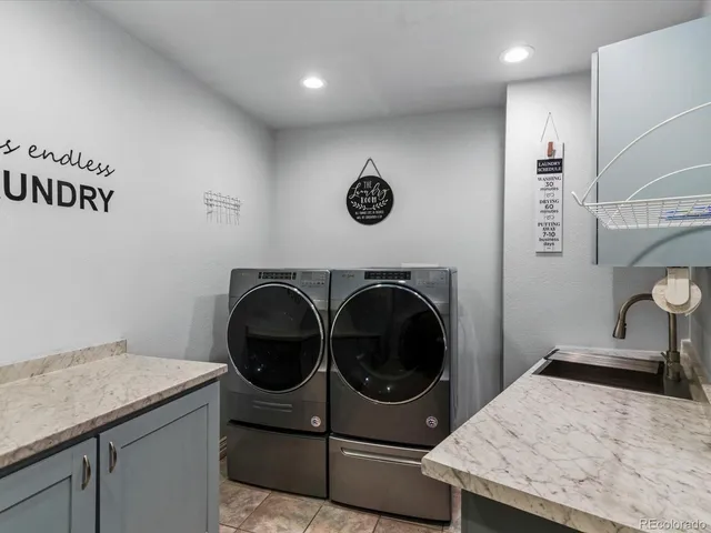 a utility room with sink dryer and washer