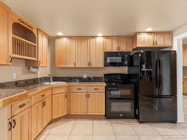 a kitchen with stainless steel appliances granite countertop a refrigerator and a stove top oven