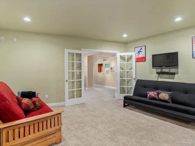 a living room with furniture a large window with kitchen view