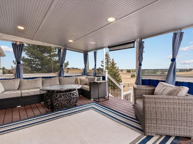 a view of a house with wooden deck and furniture