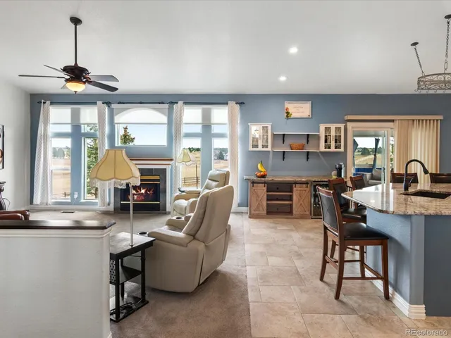 a living room with fireplace furniture and a large window