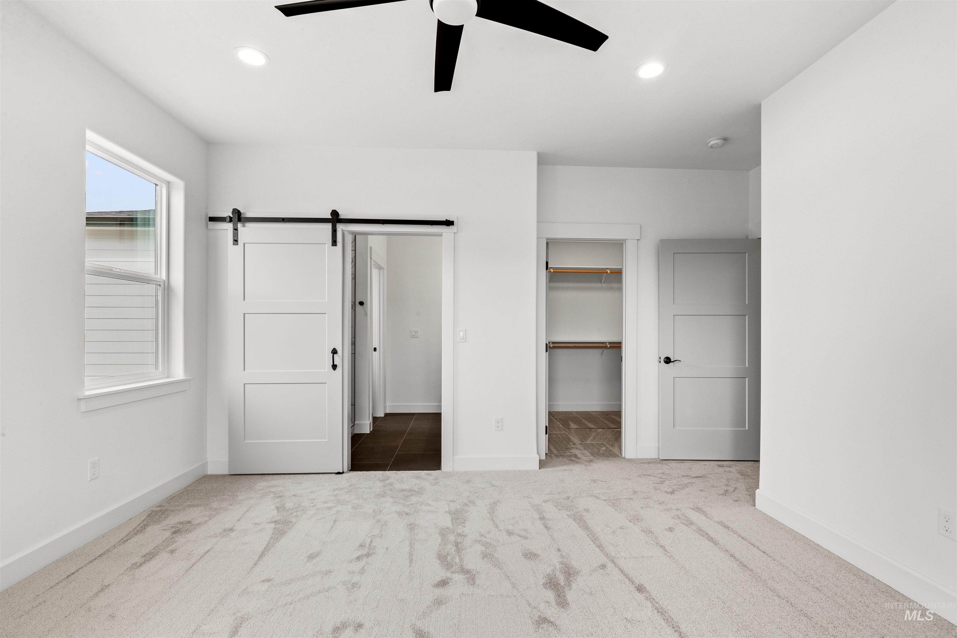 1724 Pathway Court Lewiston, ID 83501 - Photo 20 of 38 Unfurnished bedroom with a barn door, a spacious closet, carpet flooring, ceiling fan, and recessed lighting