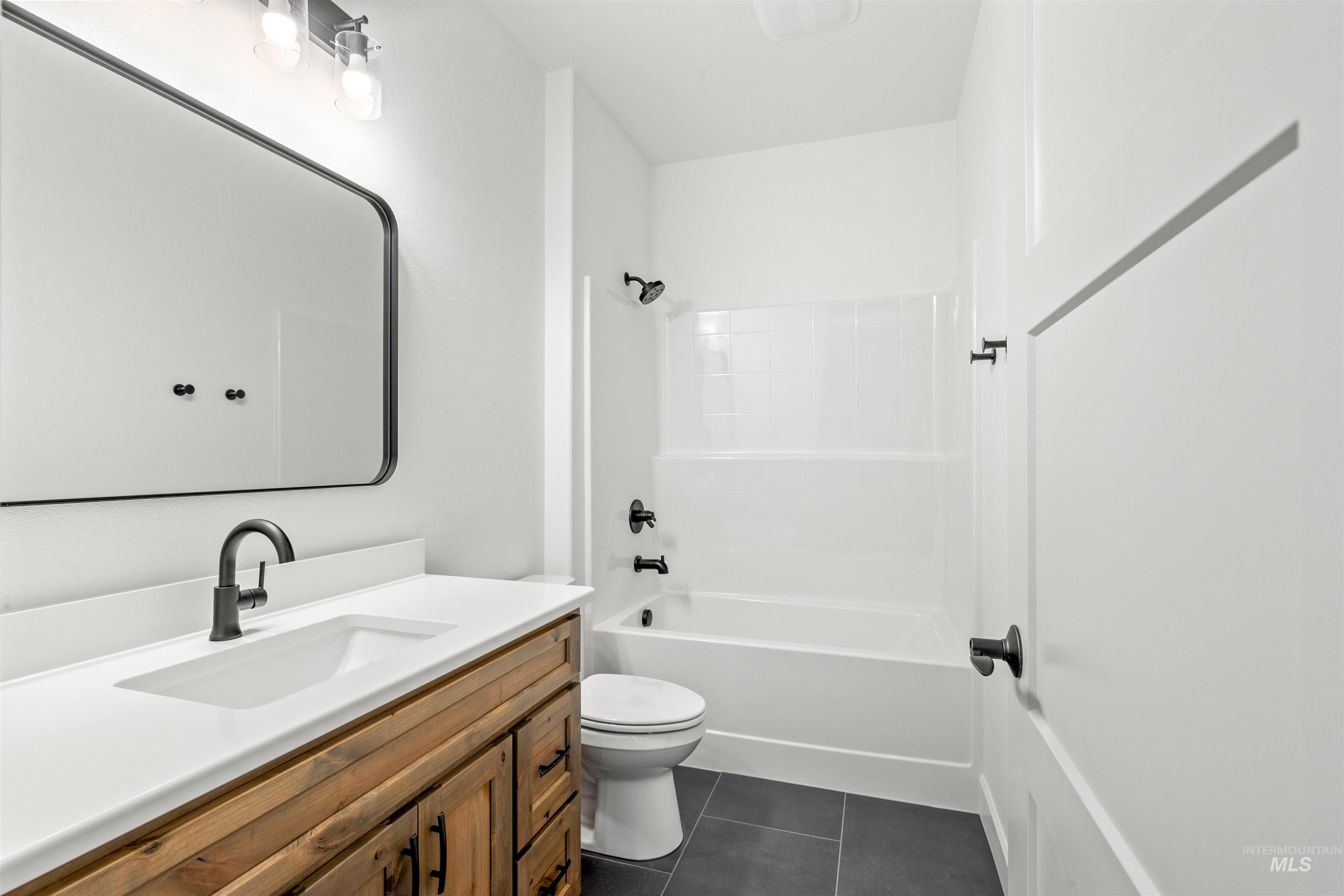 1724 Pathway Court Lewiston, ID 83501 - Photo 28 of 38 Bathroom featuring vanity, shower combination, and dark tile patterned flooring