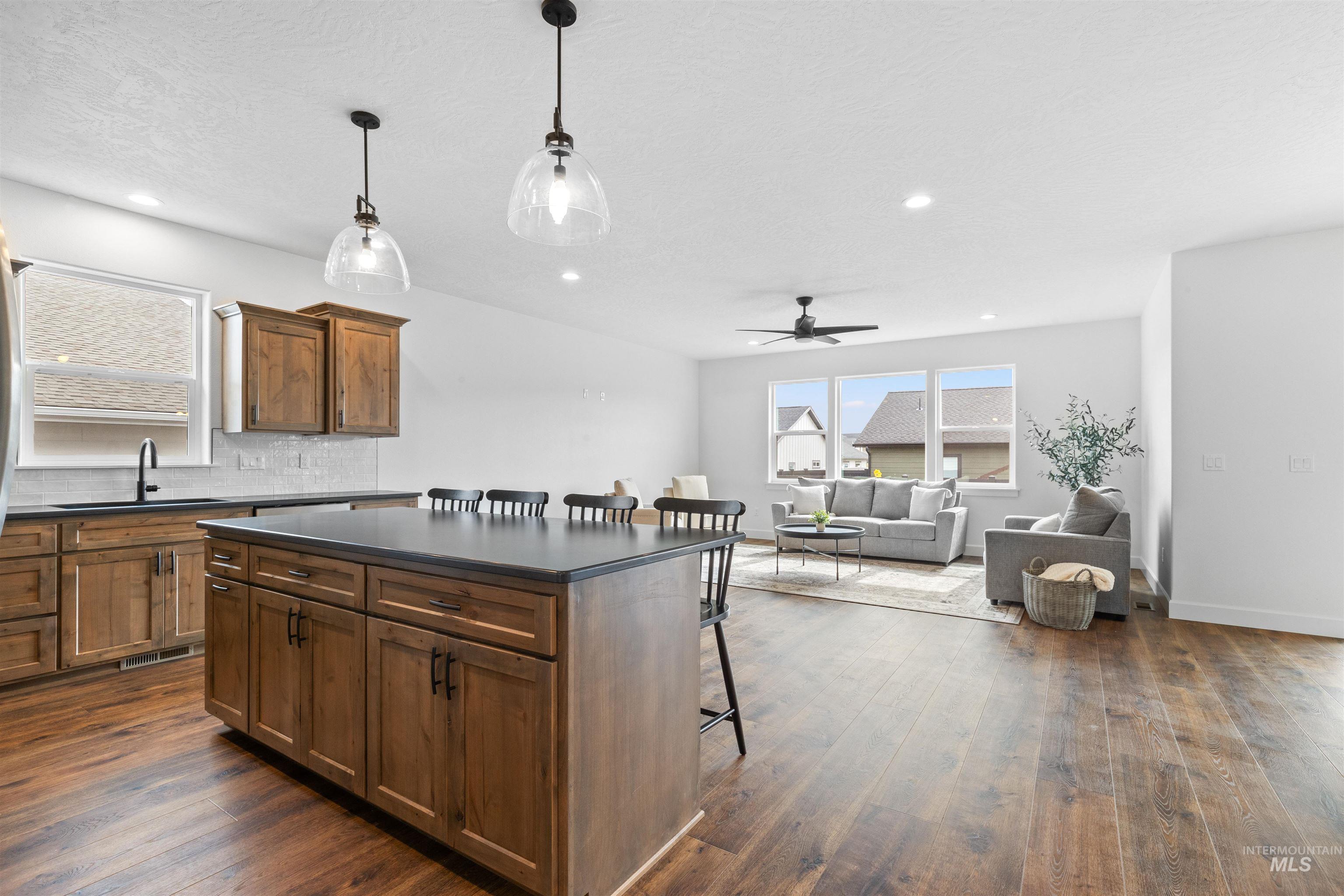 1724 Pathway Court Lewiston, ID 83501 - Photo 10 of 38 Kitchen with a kitchen bar, dark countertops, a kitchen island, and backsplash