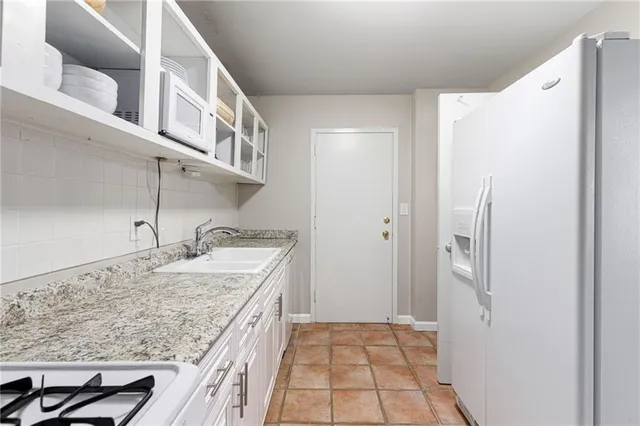 a kitchen with a granite countertop refrigerator and a sink