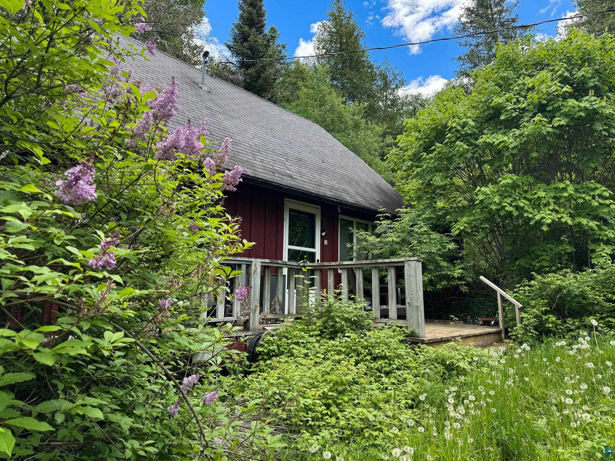 465 South Gunflint Lake Road Grand Marais, MN 55604 - Photo 3 of 46 Exterior featuring red siding, a dark shingle roof, and a prominent green entry door