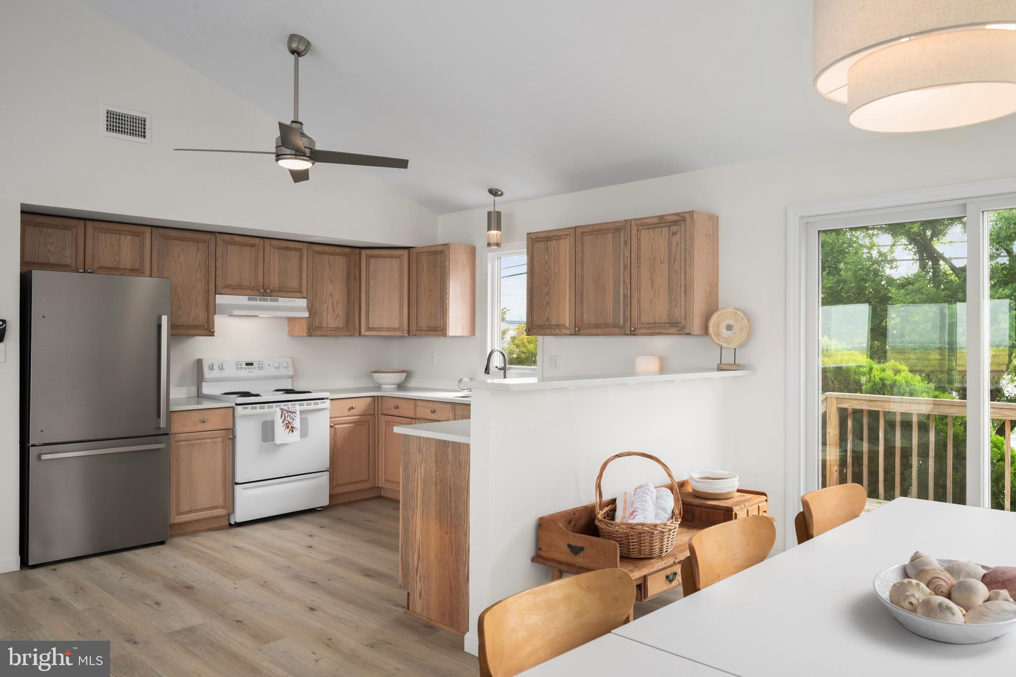 26 Butler Road Long Beach Township, NJ 08006 - Photo 16 of 44 a kitchen with stainless steel appliances granite countertop a refrigerator a sink dishwasher a stove and white countertops with wooden floor