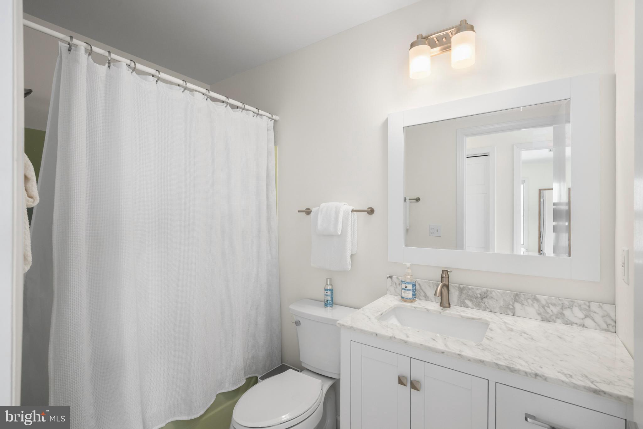 26 Butler Road Long Beach Township, NJ 08006 - Photo 32 of 44 a bathroom with a granite countertop sink toilet and mirror