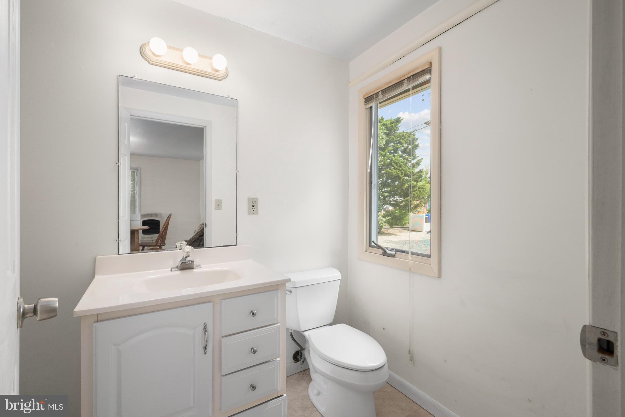 26 Butler Road Long Beach Township, NJ 08006 - Photo 36 of 44 a bathroom with a toilet sink and mirror