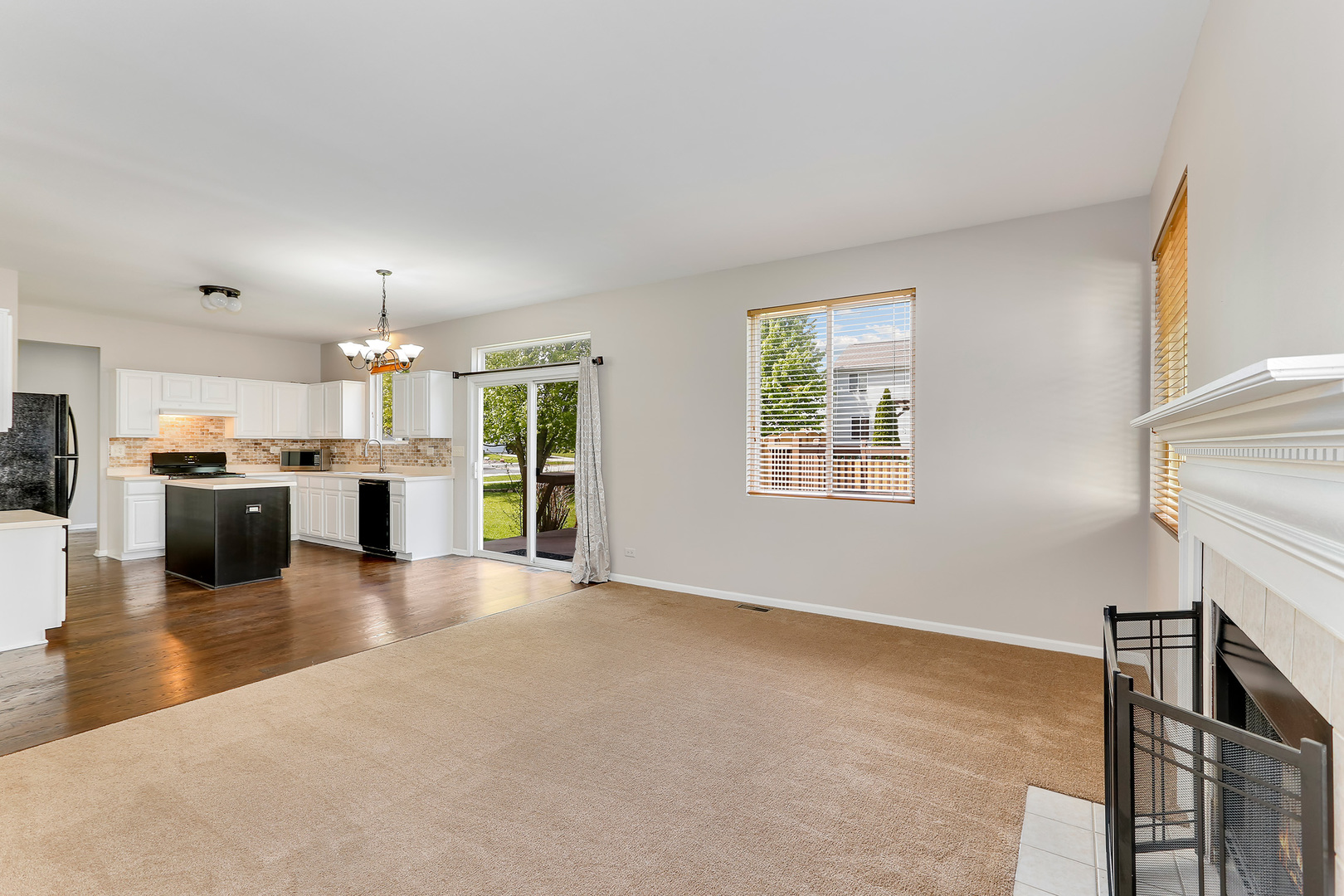 24340 Hemlock Drive Plainfield, IL 60585 - Photo 14 of 33 a view of a kitchen with kitchen island wooden floors stainless steel appliances and windows