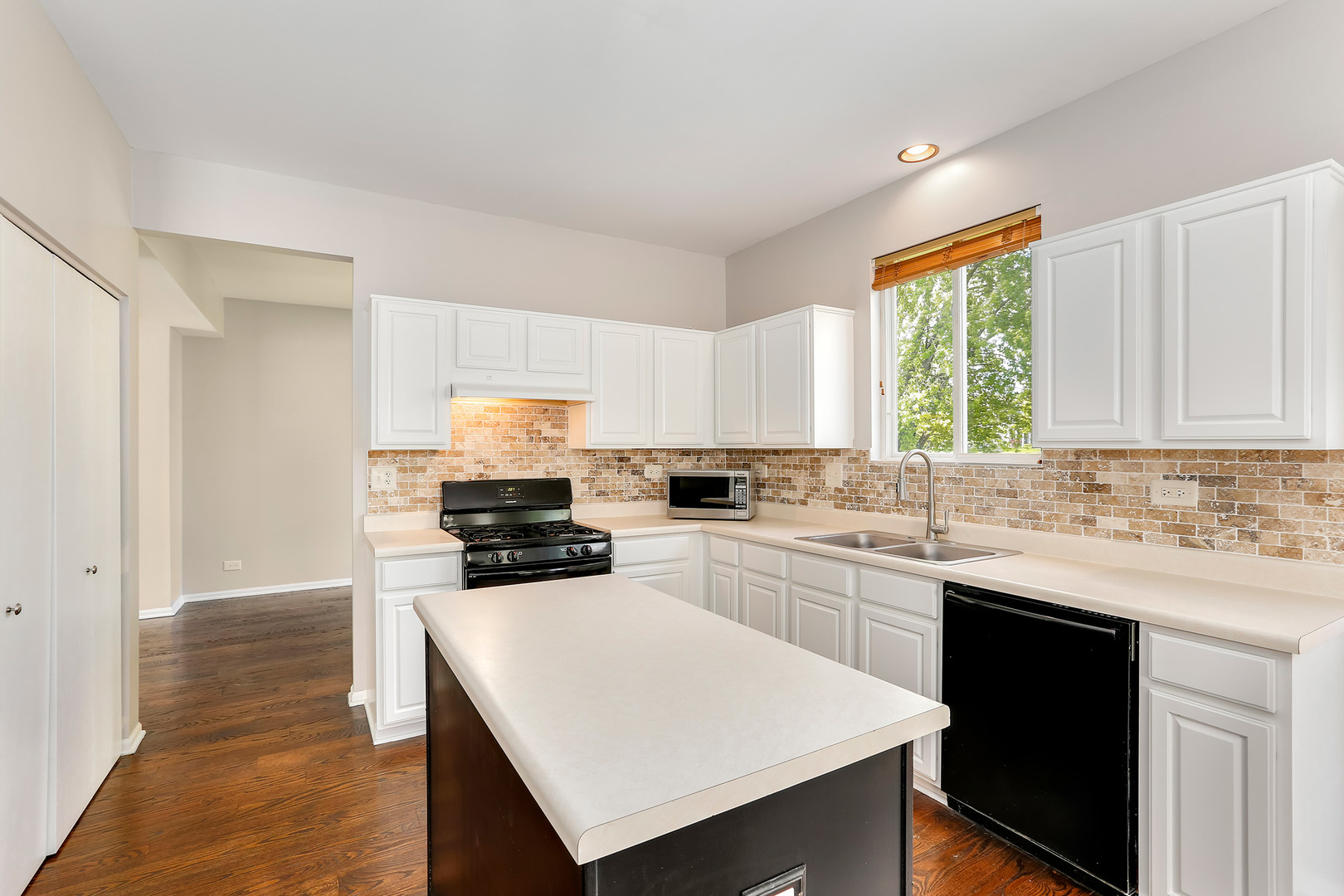 24340 Hemlock Drive Plainfield, IL 60585 - Photo 7 of 33 a kitchen with a sink stove top oven and refrigerator