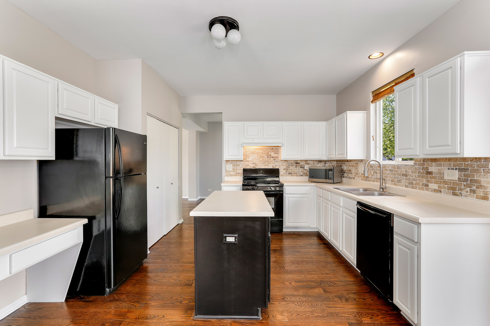 24340 Hemlock Drive Plainfield, IL 60585 - Photo 8 of 33 a kitchen with a sink stove and refrigerator