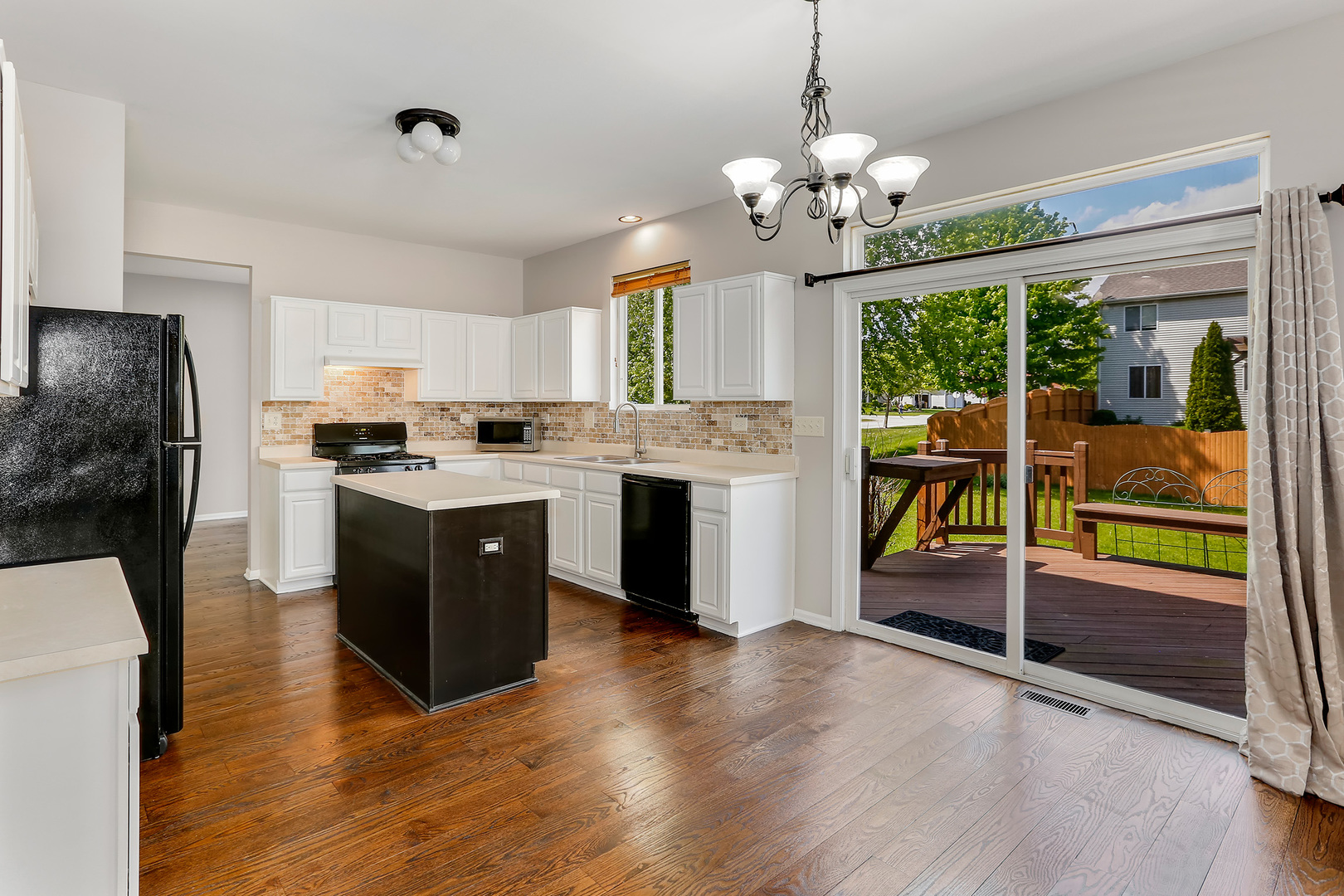 24340 Hemlock Drive Plainfield, IL 60585 - Photo 9 of 33 a kitchen with kitchen island granite countertop a stove a sink a refrigerator with a dining table and chairs