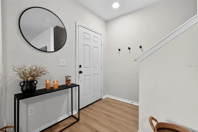 an entryway with wooden floor and mirror