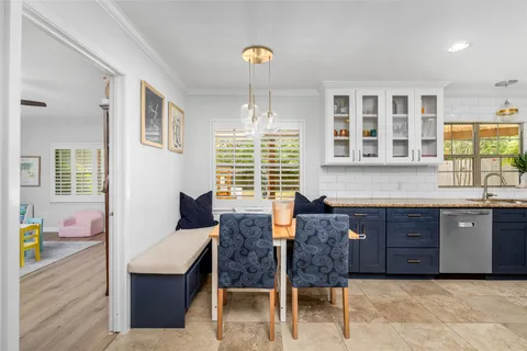 a kitchen with granite countertop wooden cabinets and dining table