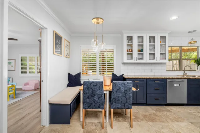 a kitchen with granite countertop wooden cabinets and dining table