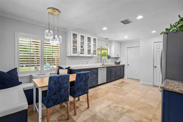 a kitchen with a table chairs refrigerator and cabinets