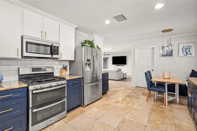 a kitchen with stainless steel appliances a stove a sink a microwave and a refrigerator