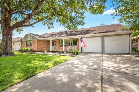 a front view of a house with a garden and yard