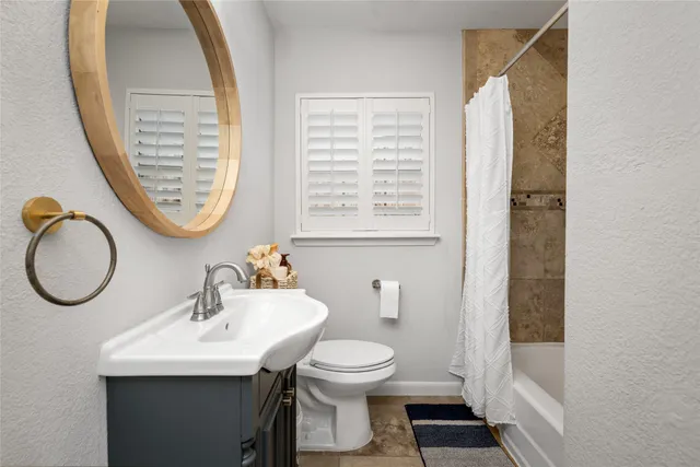 a bathroom with a sink a toilet and a mirror