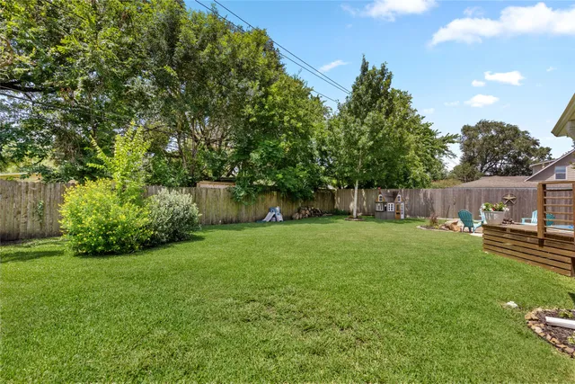 a view of a backyard with table and chairs and wooden fence