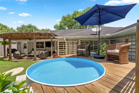 a view of a house with backyard sitting area and swimming pool