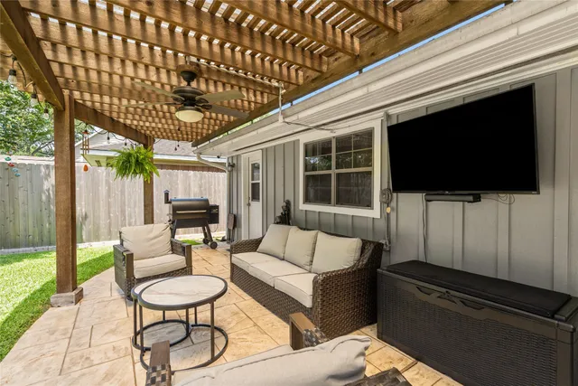 a living room with furniture a flat screen tv and a floor to ceiling window