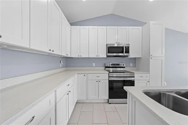 a kitchen with white cabinets and stainless steel appliances