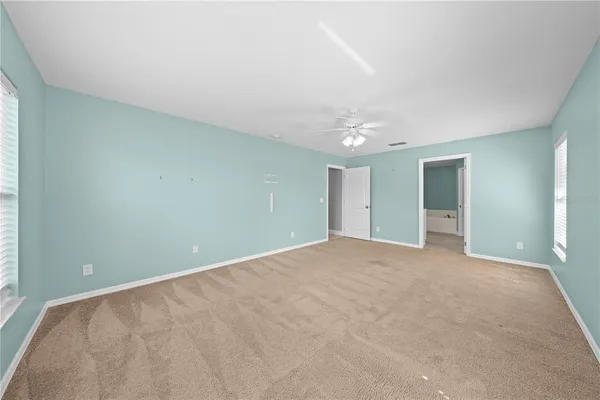 a view of an empty room with closet and a window