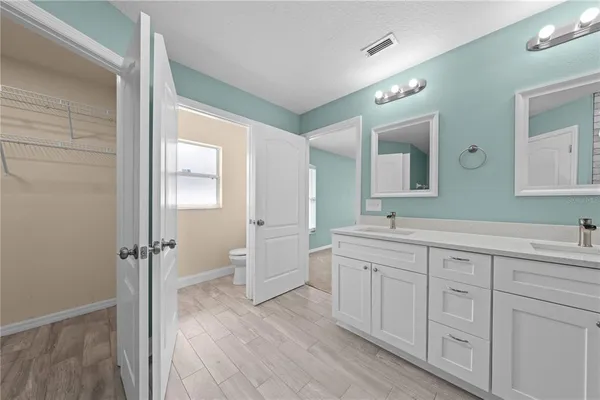 a spacious bathroom with a double vanity sink a mirror and a shower