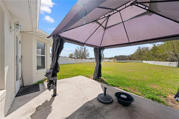 a view of a patio with a table chairs under an umbrella