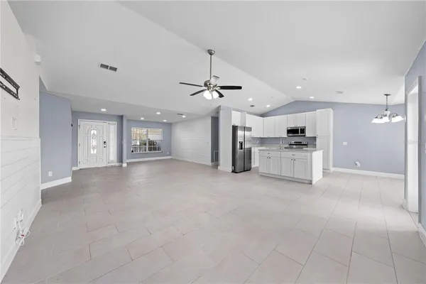 a view of a kitchen with refrigerator and a stove top oven