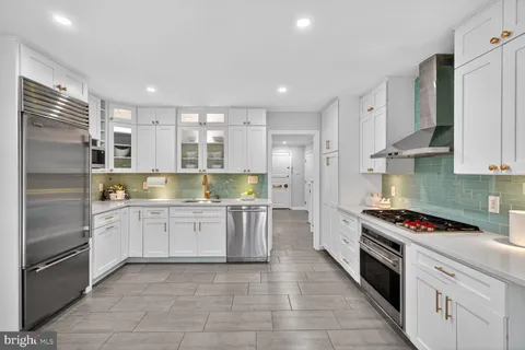 a kitchen with stainless steel appliances granite countertop a refrigerator and a stove top oven
