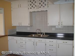 3607 South Travis Street Amarillo, TX 79110 - Photo 3 of 3 a kitchen with granite countertop white cabinets and sink