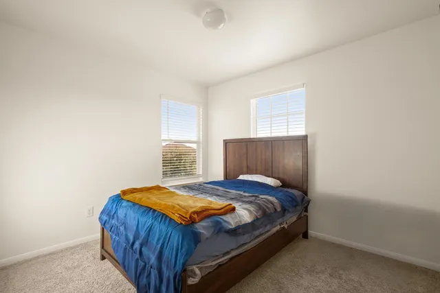 a bed sitting in a bedroom next to a window