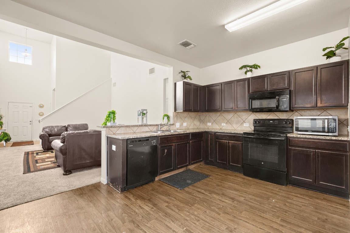 14504 Callan Court Manor, TX 78653 - Photo 7 of 22 a kitchen with stainless steel appliances granite countertop a sink and stove top oven