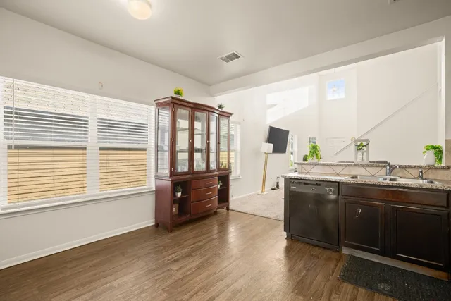 a view of kitchen with granite countertop a sink and a stove top oven