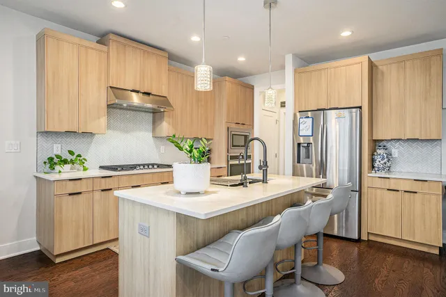 a kitchen with kitchen island granite countertop a sink cabinets and wooden floor