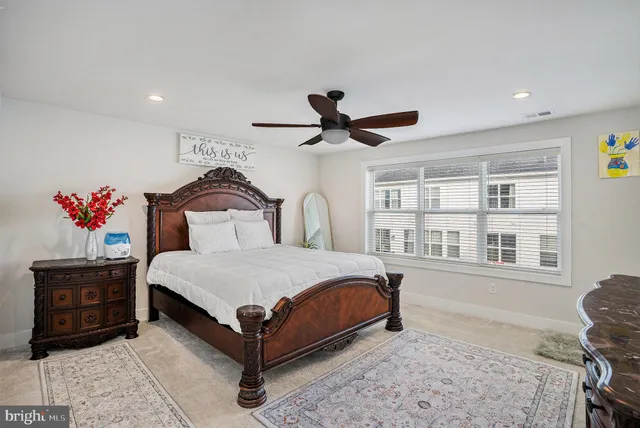 a bedroom with a bed a dresser and a chandelier