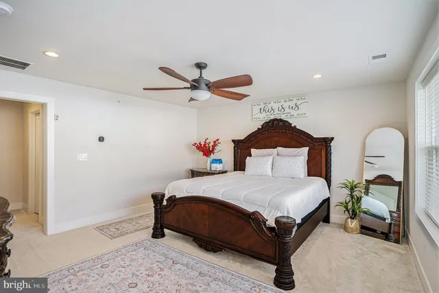 a bedroom with a bed a ceiling fan and a dresser
