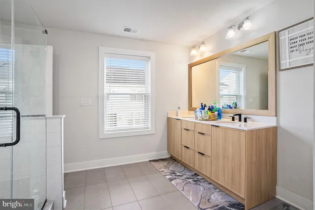 a bathroom with a granite countertop sink mirror and a bathtub