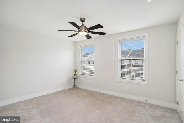 an empty room with a window and a fan