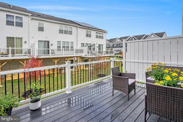 a view of a house with a wooden deck and furniture