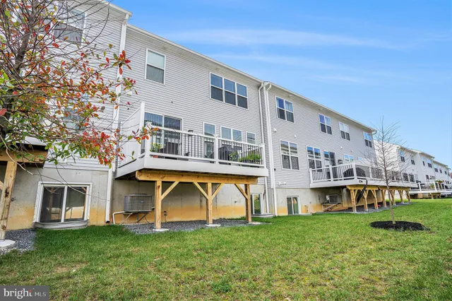 a view of house with a big yard and large trees
